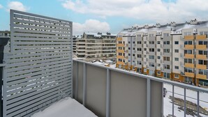 A balcony with a metal railing, overlooking a residential area with multi-story buildings. - Sunny Apartment | Balcony and Private Parking (Wrocław)