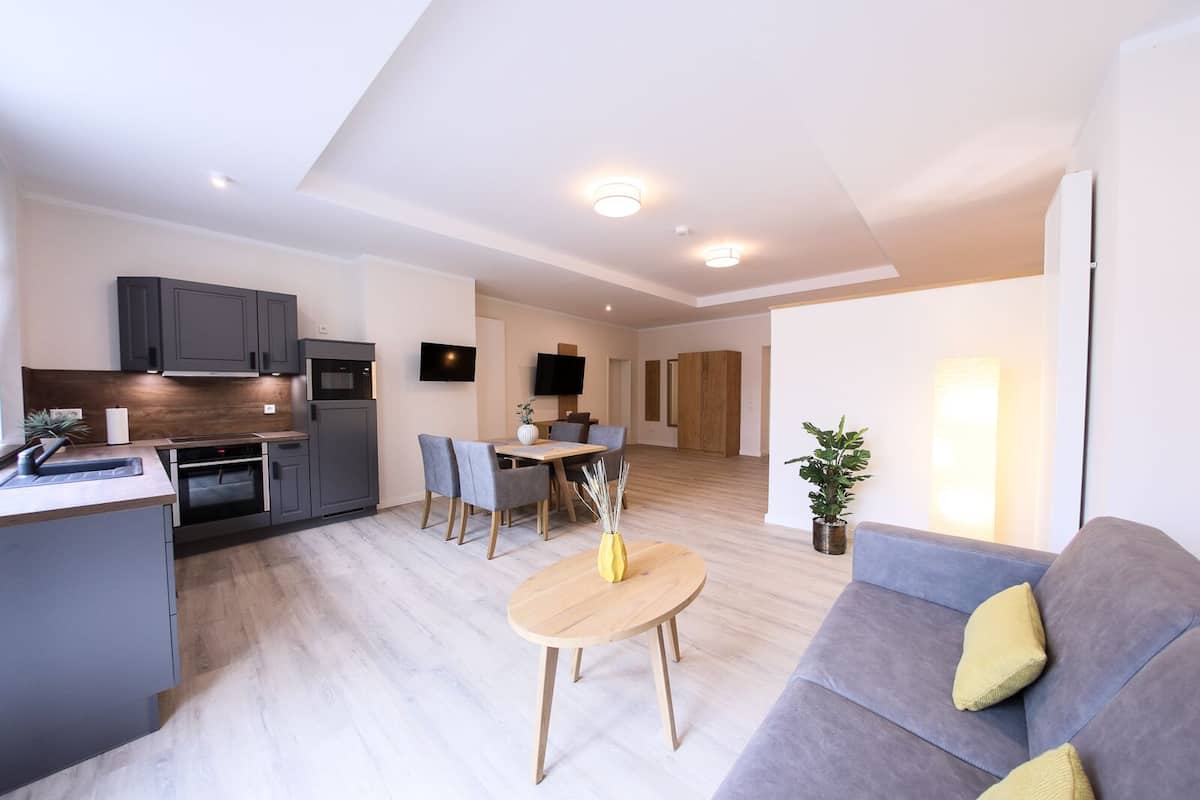 A modern apartment with a kitchen, dining area, and living room.