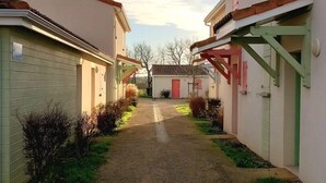 A residential street with houses on either side, a gravel path, and a clear sky. - Little Happiness house residence with pool & spa (Talmont-Saint-Hilaire)