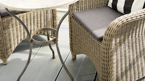 A wicker outdoor seating area with a round table and a potted plant. - Berliner Hof, Apartment 6 (55sqm), Westerland, Sylt. (Sylt)