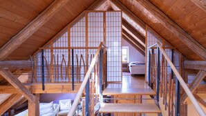 Un intérieur en bois avec un plafond haut et un escalier menant à un niveau supérieur.