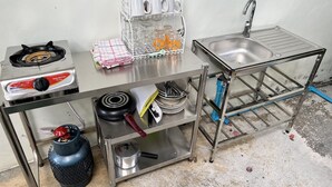 A compact kitchenette with a gas stove, sink, and storage shelves. - Spacious Private Pool Villa (Tambon Rawai)