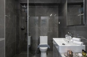 City appartement | Badkamer | Een douche, een haardroger, handdoeken, zeep