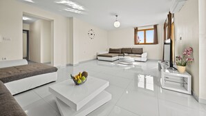 Un saló modern amb un sofà, una taula de centre i una taula auxiliar petita amb una planta.