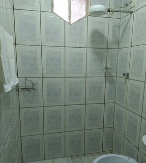 Ein Badezimmer mit Dusche, gefliesten Wänden und Toilette.