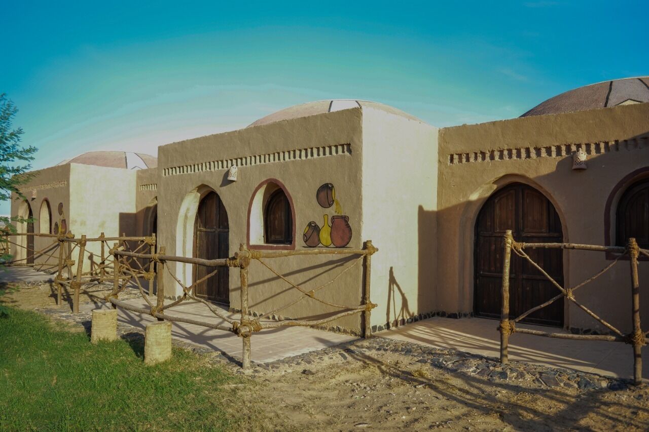 Un bâtiment traditionnel doté de plusieurs portes en arc de cercle et d’une cour intérieure.