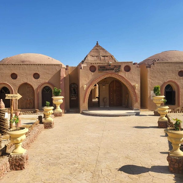 A traditional building with a central archway, multiple doorways, and a reception area.