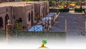 Un edificio tradicional con ventanas de arco y un patio con piscina.