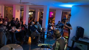 Un grupo de personas cenando en un restaurante con una banda tocando en vivo.