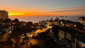 Un paisaje urbano costero al atardecer, con edificios y vista al mar.
