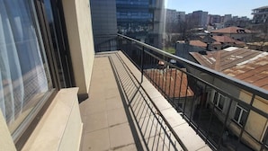 A balcony with a metal railing overlooking a residential area with various buildings. - Dacia Residence Apartments (Bucharest)