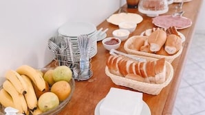 A buffet table with various food items, including fruits, bread, and condiments. - Nacional Park Hotel Lages (Lages)