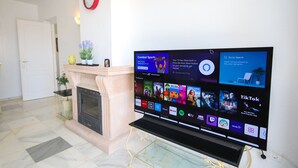 Ein modernes Wohnzimmer mit einem Flachbildfernseher, der verschiedene Streaming-Apps anzeigt.