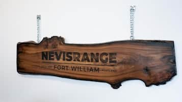 Une enseigne en bois portant l’inscription « NEVISRANGE, fondé en 1989, FORT WILLIAM, ÉCOSSE ».