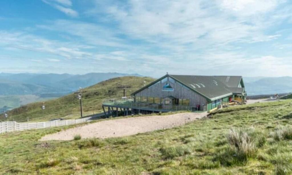 Une cabane rustique avec un toit en pente, une véranda et une vue sur le paysage environnant.