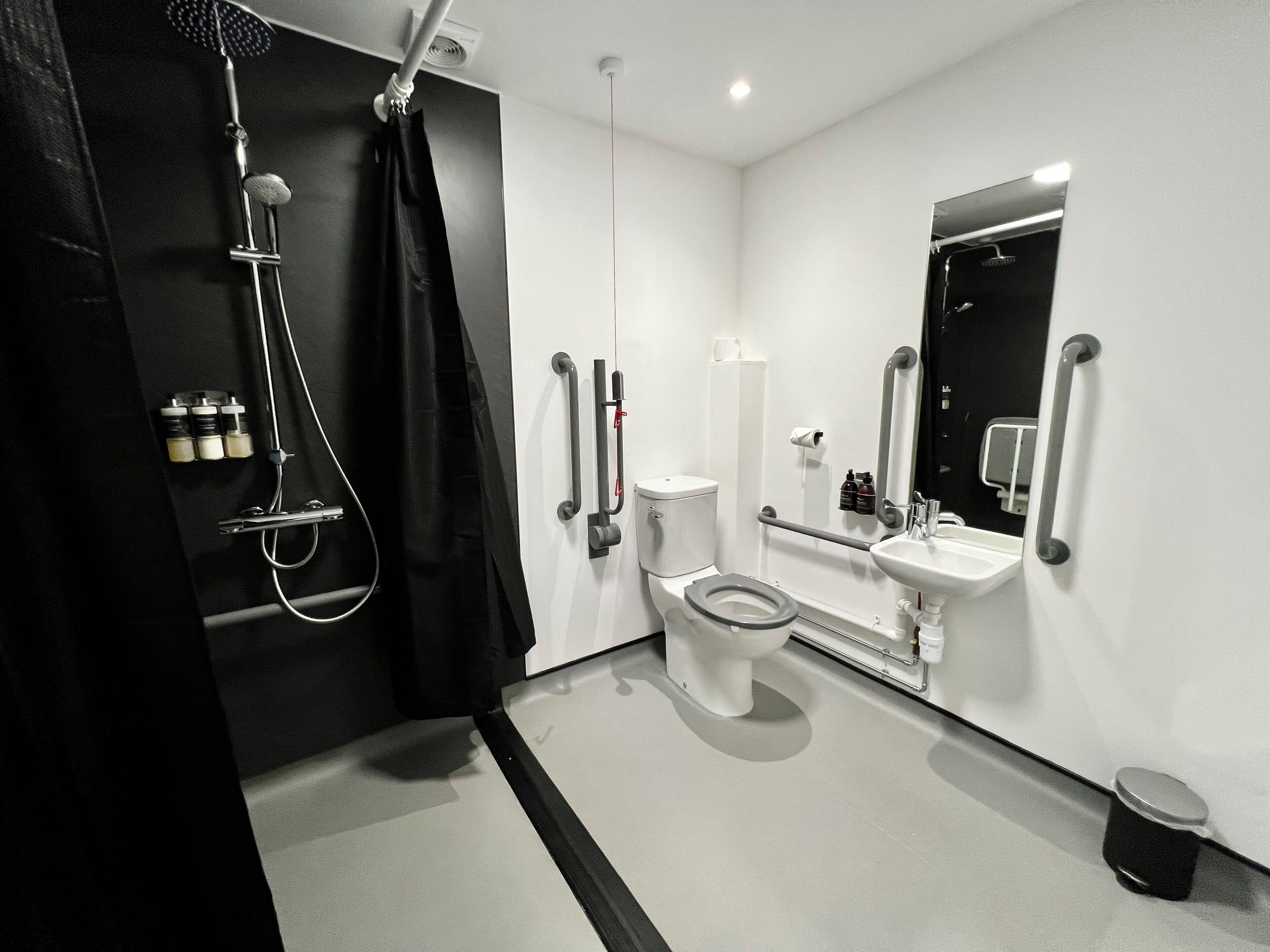 A modern bathroom with a toilet, sink, and shower.