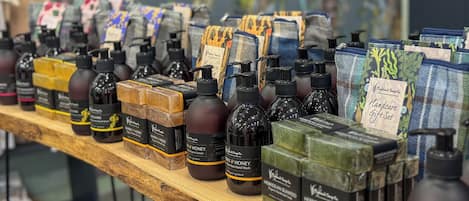 A shelf with various skincare products, including lotions and soaps, displayed on a wooden surface.