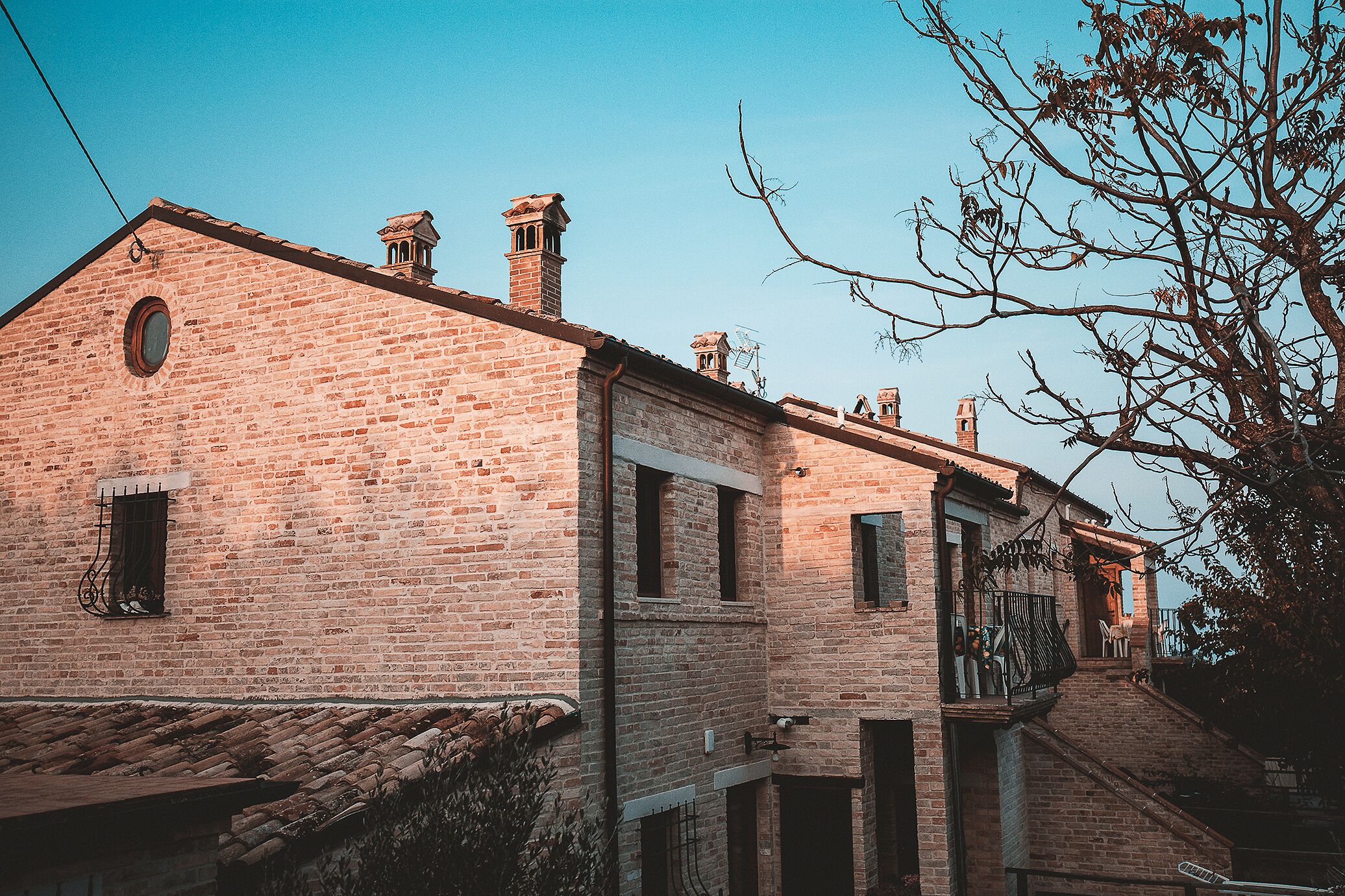 A brick building with a small balcony and a staircase leading to a second floor.