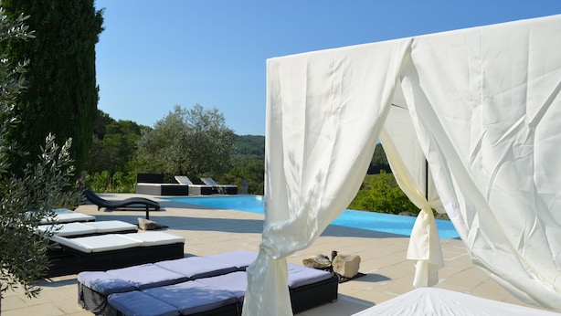 A poolside area with sun loungers and a canopy. - Stone house with beautiful swimming pool and enchanting panorama (Seguret)