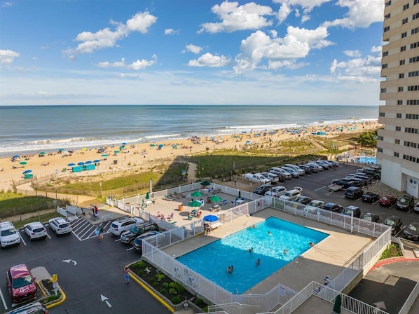 Un hôtel doté d'une piscine, offrant une vue sur la plage et disposant d'un parking.