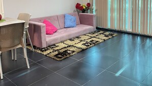 Un salon moderne avec un canapé, une table à manger et un lustre.