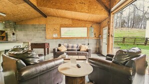 Ein gemütlicher Innenraum mit Ledersofas, einem Holztisch und einer Ziegelwand.