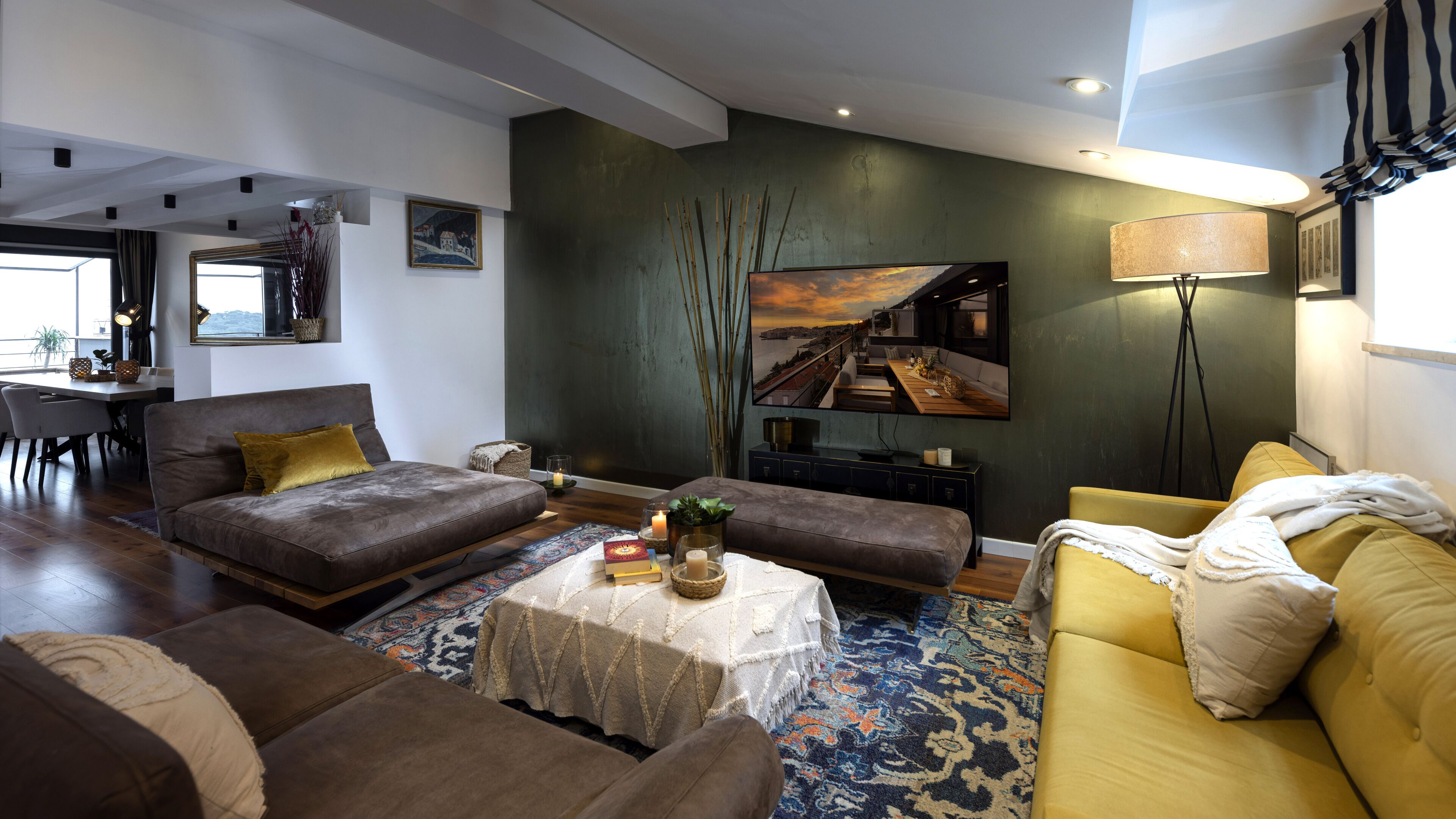 Uma sala de estar moderna com um sofá, uma mesa de centro e uma área de jantar com mesa e cadeiras.