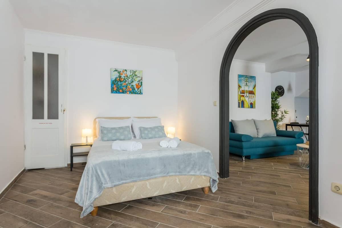 Un dormitorio con cama, mesitas de noche y un cuadro en la pared.