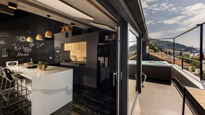 A modern kitchen with a marble countertop, pendant lights, and a view of the city through large windows. - Dubrovnik Old Town Apartments (Dubrovnik)