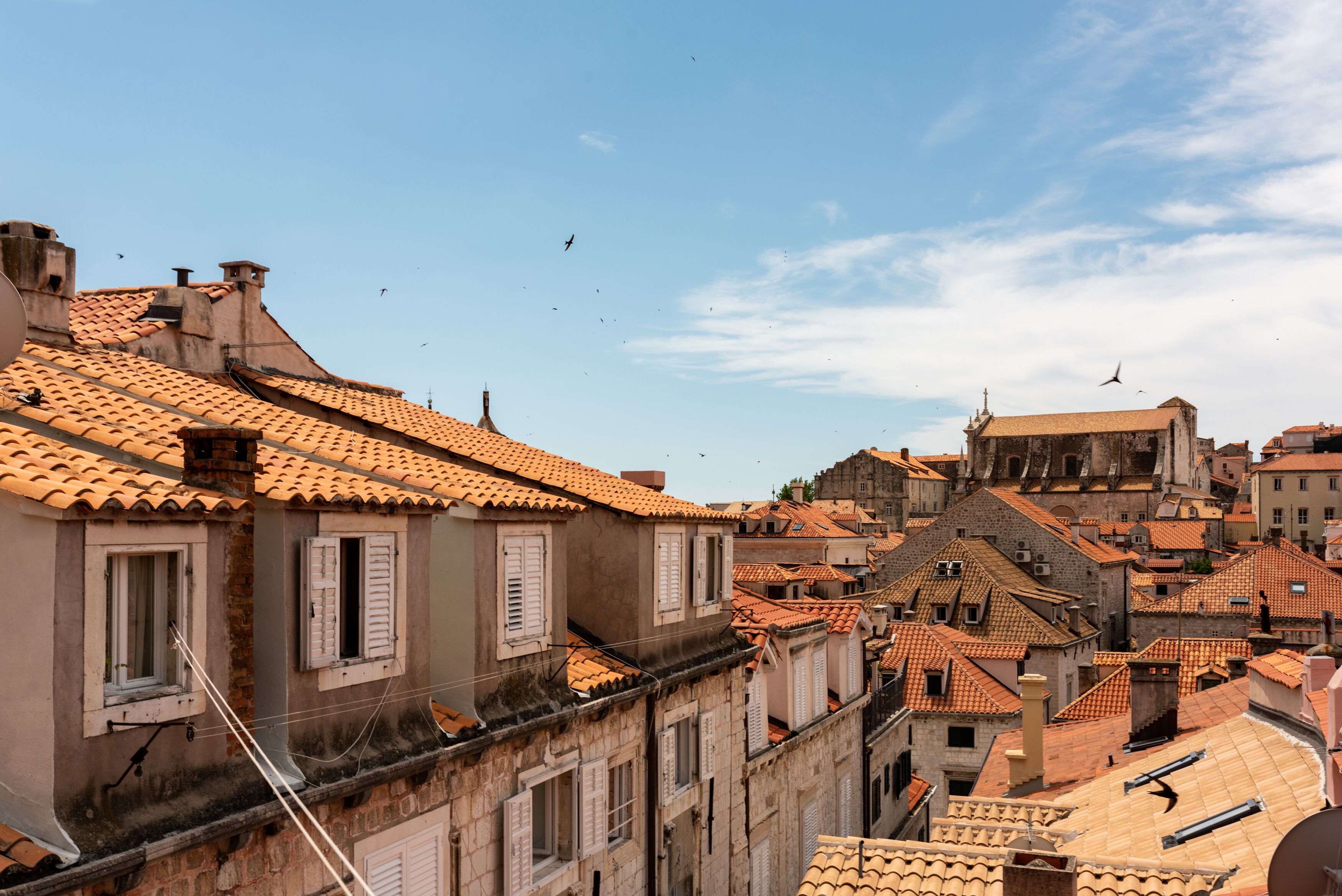 A view of a historic town with terracotta-tiled roofs and traditional architecture.