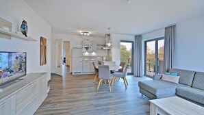 Un appartamento moderno con cucina, zona pranzo e soggiorno.