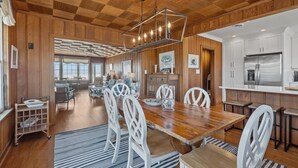 A spacious kitchen with a wooden ceiling, white cabinets, and a stainless steel refrigerator. - Blount Cottage-Oceanfront, Pet Friendly Home in Atlantic Beach, NC (Atlantic Beach)