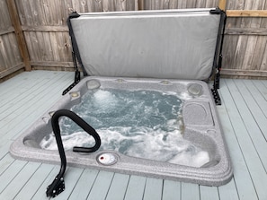 A portable hot tub with a cover, a control panel, and a pump. - Creekside Hot Tub House (Hope Mills)