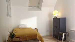A bedroom with a bed, a nightstand, a lamp, a cabinet, and a small stool. - The House of Strikes... its Dependency (Le Val-Saint-Père)