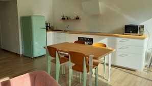 A modern kitchen with white cabinets, a wooden countertop, and a teal refrigerator. - The House of Strikes... its Dependency (Le Val-Saint-Père)