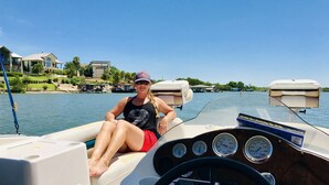 Una persona en un barco con un tablero mostrando indicadores de velocidad y revoluciones.