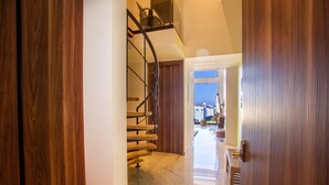 Un intérieur moderne avec un escalier en bois menant à un balcon.
