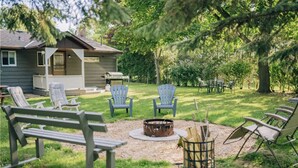 A backyard with outdoor seating, a fire pit, and a grill area. - Centrally located spacious cottage just steps from beach and downtown! (Bayfield)