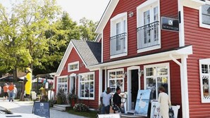 A red building with multiple windows and a balcony, likely a commercial establishment. - Centrally located spacious cottage just steps from beach and downtown! (Bayfield)