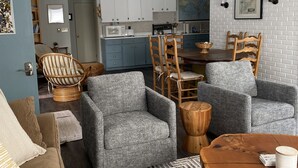 A modern living room with a grey sofa, a wooden coffee table, and a patterned rug. - Centrally located spacious cottage just steps from beach and downtown! (Bayfield)