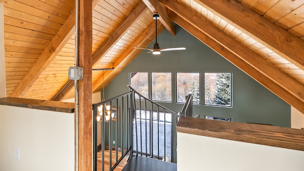 A wooden ceiling with a fan, a staircase, and a view of trees outside. - The Fishermen’s Place: Mountain Views + Dog Friendly (Breckenridge)