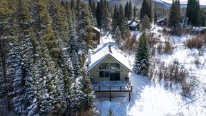 A cabin surrounded by snow-covered trees and mountains. - The Fishermen’s Place: Mountain Views + Dog Friendly (Breckenridge)