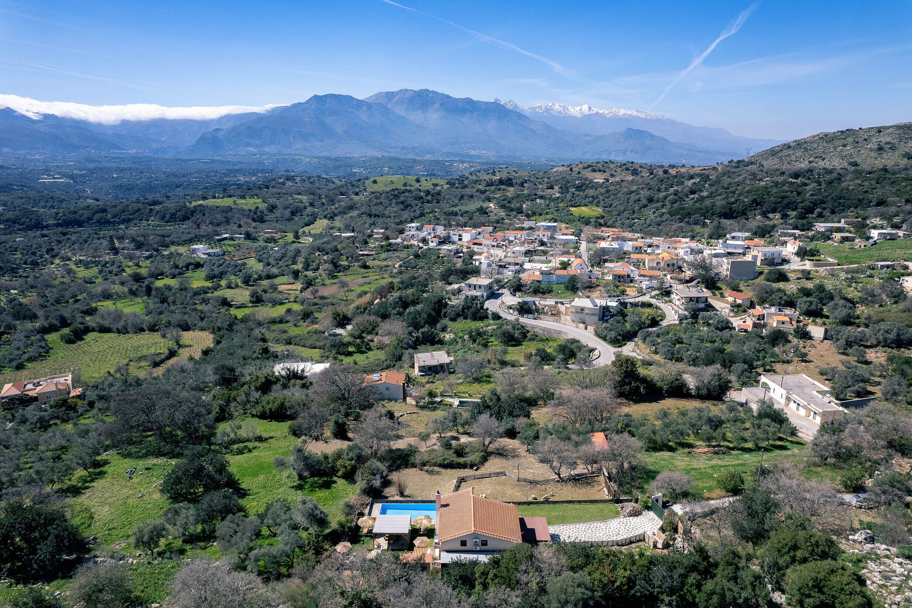 A coastal village with a mix of residential buildings and open green spaces.