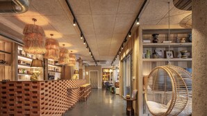 Un intérieur moderne avec un comptoir aux motifs de briques, des lampes suspendues en rotin et un fauteuil suspendu en rotin.