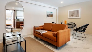 A modern living room with a sofa, a glass coffee table, and a dining area with chairs. - w* | Cool 1BR with Amazing Deco in Polanco (Ciudad de México)