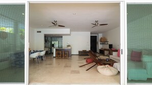 A spacious living area with a kitchen, dining space, and a green couch. - NEW LISTING! PRIVATE POOL CONDO ON 5TH AVE, BBQ, PARKING, 2min walk to beach (Playa del Carmen)