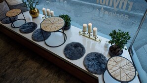 A table with decorative items and candles, a small plant, and a window with a view of the street. - Hotel Rhyhof (Frauenfeld)