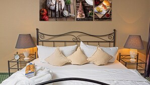 A neatly made bed with white linens and beige pillows, a bedside table with a lamp, and a wall-mounted picture of food items. - Hotel Rhyhof (Frauenfeld)
