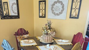 Una taula de dinar rodona de fusta, amb un centre de taula floral, envoltada de cadires antigues.
