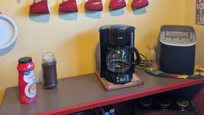 Espai cafè amb cafetera, tasses i un bocal de cafè.